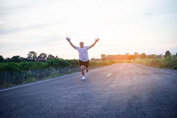 young man runner running on running road in city park