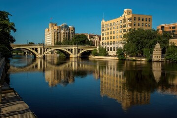 Naklejka premium Flint River: Urban Landscape Featuring Iconic Architecture, Serene Water Bridges, and Scenic Park Views