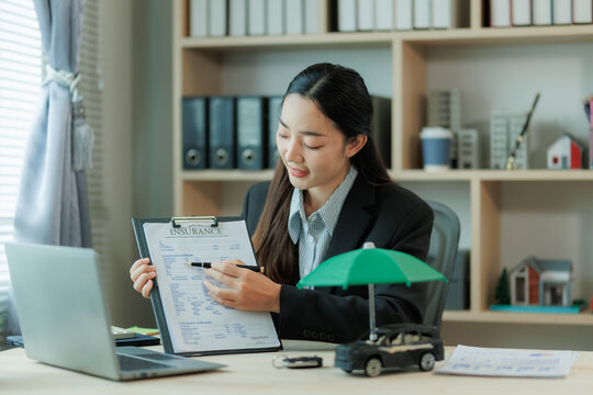 Insurance agent discusses vehicle coverage and contract details with a client, highlighting trust, policy terms, and customer service in the automotive finance process.