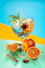 Summer cocktail with gin, tonic, blood orange, cinnamon, anise, and rosemary.