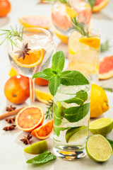 Refreshing summer cocktails with citrus on a white marble table.