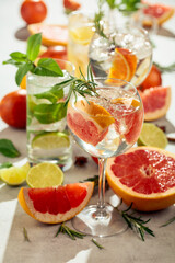 Refreshing summer cocktails with citrus on a white marble table.