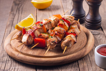 Delicious grilled chicken skewers with capsicum, lemon, salad and ketchup on a plate over the table. Chicken kebab. Healthy food concept.