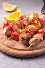 Delicious grilled chicken skewers with capsicum, lemon, salad and ketchup on a plate over the table. Chicken kebab. Healthy food concept.