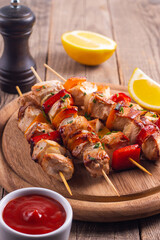 Delicious grilled chicken skewers with capsicum, lemon, salad and ketchup on a plate over the table. Chicken kebab. Healthy food concept.