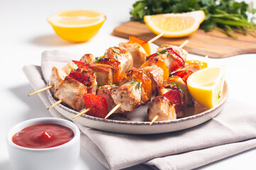 Delicious grilled chicken skewers with capsicum, lemon, salad and ketchup on a plate over the table. Chicken kebab. Healthy food concept.