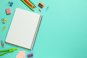 Assorted educational supplies including pen, notebooks, and stationery placed on a color surface