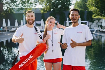 Lifeguards showing thumbs up by the poolside