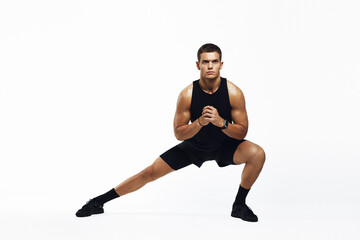 Young male executing a powerful side lunge in a bright, minimalist studio, showcasing athleticism...