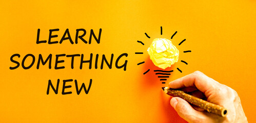 Learn something new symbol. Concept words Learn something new. Beautiful orange background. Businessman hand with pencil. Business motivational lifestyle learn something new concept. Copy space.
