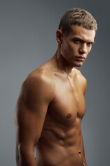 Fototapeta premium A fit male exuding confidence as he displays his well defined muscles in a professional studio setting, embodying strength and focus. Ideal for fitness marketing and branding materials.