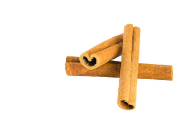 Dried cinnamon bark pieces scattered on white, showcasing their organic shapes and warm brown tones.