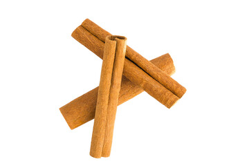 Flat lay of cinnamon bark shards on white, emphasizing their organic forms and warm brown...