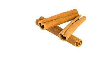 Cinnamon bark curls and chips spread across a white background, showcasing their aromatic appeal and texture.