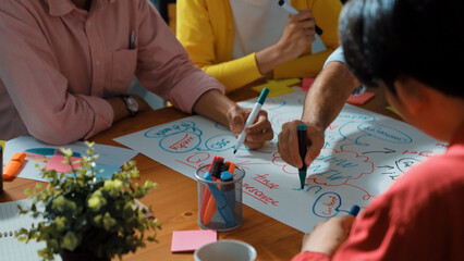 Obraz premium Group of people using mind map sharing marketing idea and brainstorm plan. Closeup of smart business working together to draw mind map by using marker and plan creative start up project. Convocation.