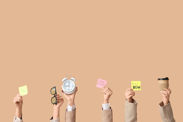 Female hands with sticky notes, alarm clock and coffee cup on beige background. Time management...