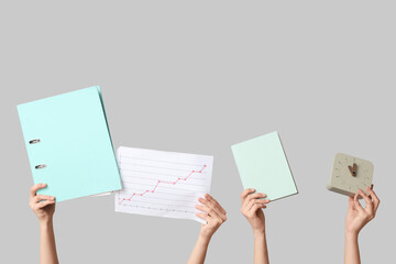 Female hands with folder, diagram, notebook and clock on grey background. Time management concept