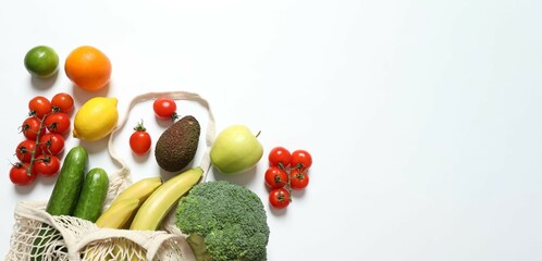 String bag with vegetables and fruits on white background. Top view