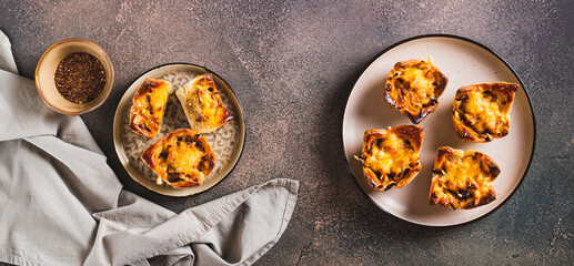 Homemade caramelized onion savory pies on a plate on the table top view web banner