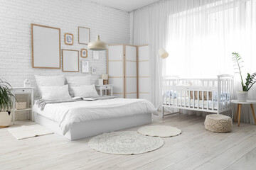 Interior of room with bed, baby crib and folding screen