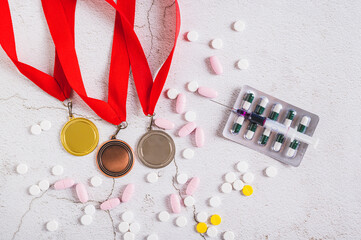 Concept of doping in sports, medals, pills and syringe on the table top view