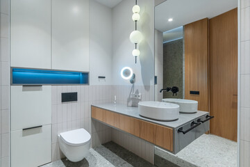 Exclusive bathroom design. Stylish lamps. A large mirror over the sink bowl.