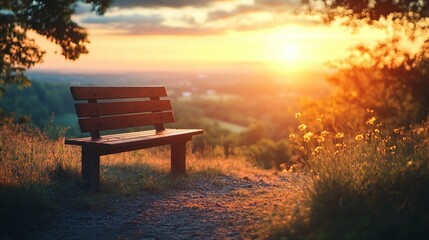 Wooden park bench at sunset overlooking a valley.  Golden light bathes the landscape