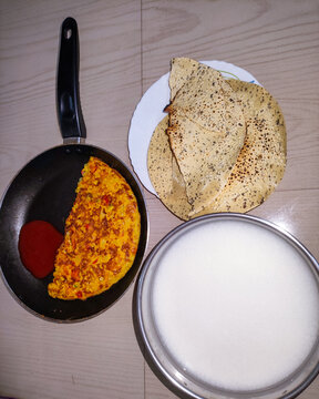 selective focus picture of pakahal (rice water), egg omelet and papad