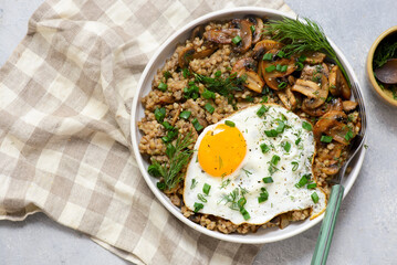 Bowl with buckwheat, fried mushrooms and fried egg for breakfast. vegeterian dish