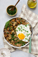 Bowl with buckwheat, fried mushrooms and fried egg for breakfast. vegeterian dish