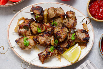 Pork shashlik on skewers with fresh vegetables and hot sauces.selective focus