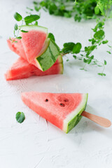 Watermelon Popsicle Slice with Mint Leaves on White Surface