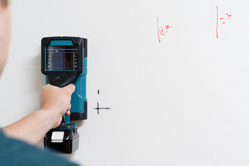Man Using Handheld Electronic Stud Finder