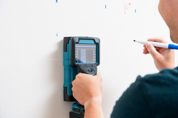 Worker Using Wall Scanner and Marking Stud Location