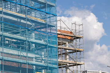 Construction site with scaffolding and blue safety net on building facade