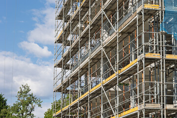 Scaffolding covering building under construction on a sunny day