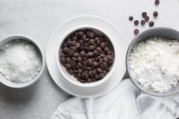 overhead view of mise en place for homemade chocolate chip cookies, ingredients for making chocolate chip cookies on a marble countertop