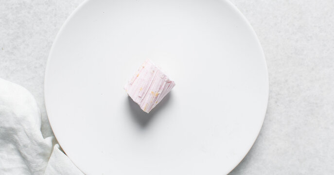 Overhead view of Nigerian Balewa candy, top view of hausa alewa candy on a white background, pulled hard sugar candy on a white countertop