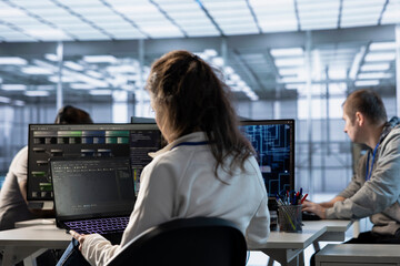IT staff member programming in AI server farm housing advanced equipment used for machine learning...