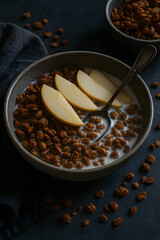 Bowl of cereal with milk and sliced apples, ready to eat, presented in a moody setting with scattered pieces