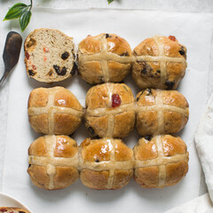 Overhead view of hot cross buns on white parchment paper, top view of hot cross buns on a white background