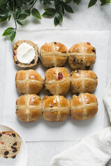 Overhead view of hot cross buns on white parchment paper, top view of hot cross buns on a white...