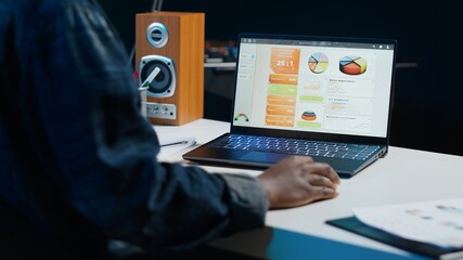 Woman working from home analyzing sales report to plan business development, handheld camera shot. Teleworker using accounting statistics graphs for project research, camera A