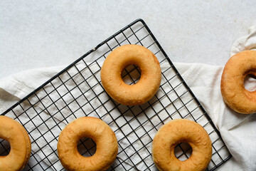 Overhead view of donuts on a cooling rack, top view of homemade doughnuts, process of making doughnuts