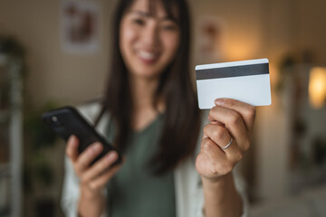 japanese woman use credit card and cellphone for shopping
