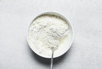 Overhead view of flour being mixed into cake batter, top view of vanilla cake batter being mixed, process of making vanilla cake