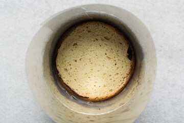 overhead view of layered cake being filled with chocolate ganache, top view of dark chocolate filling on a cake layer, process of assembling a layer cake