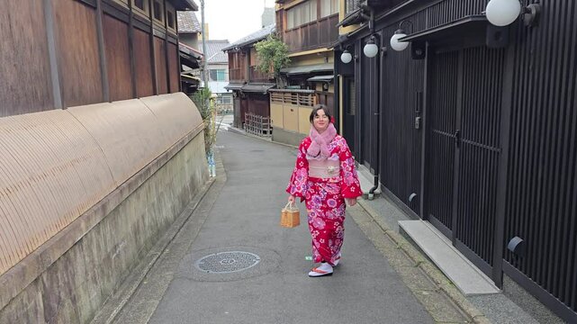 A pretty girl in a kimono. Kimono is the traditional dress worn popular in Japan. American girl posing in kimono outdoors. 