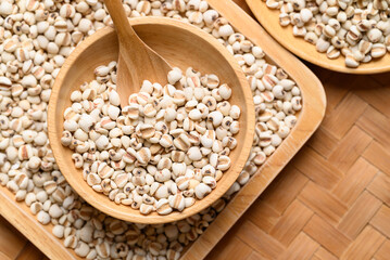 Dried Job's tears or adlay millet seeds in wooden bowl with spoon, Food ingredient, Top view