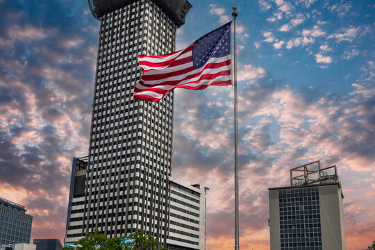 An American flag, skyscrapers and office buildings in the city skyline in New Orleans Louisiana USA - Powered by Adobe